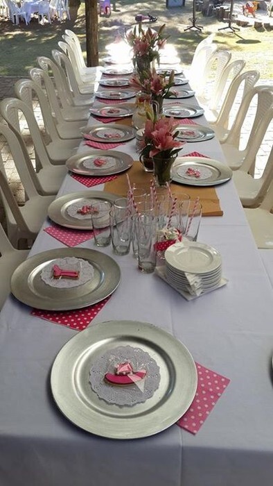 White catering chairs with no chair covers and trestle tables with white table cloths for a kitchen tea party.